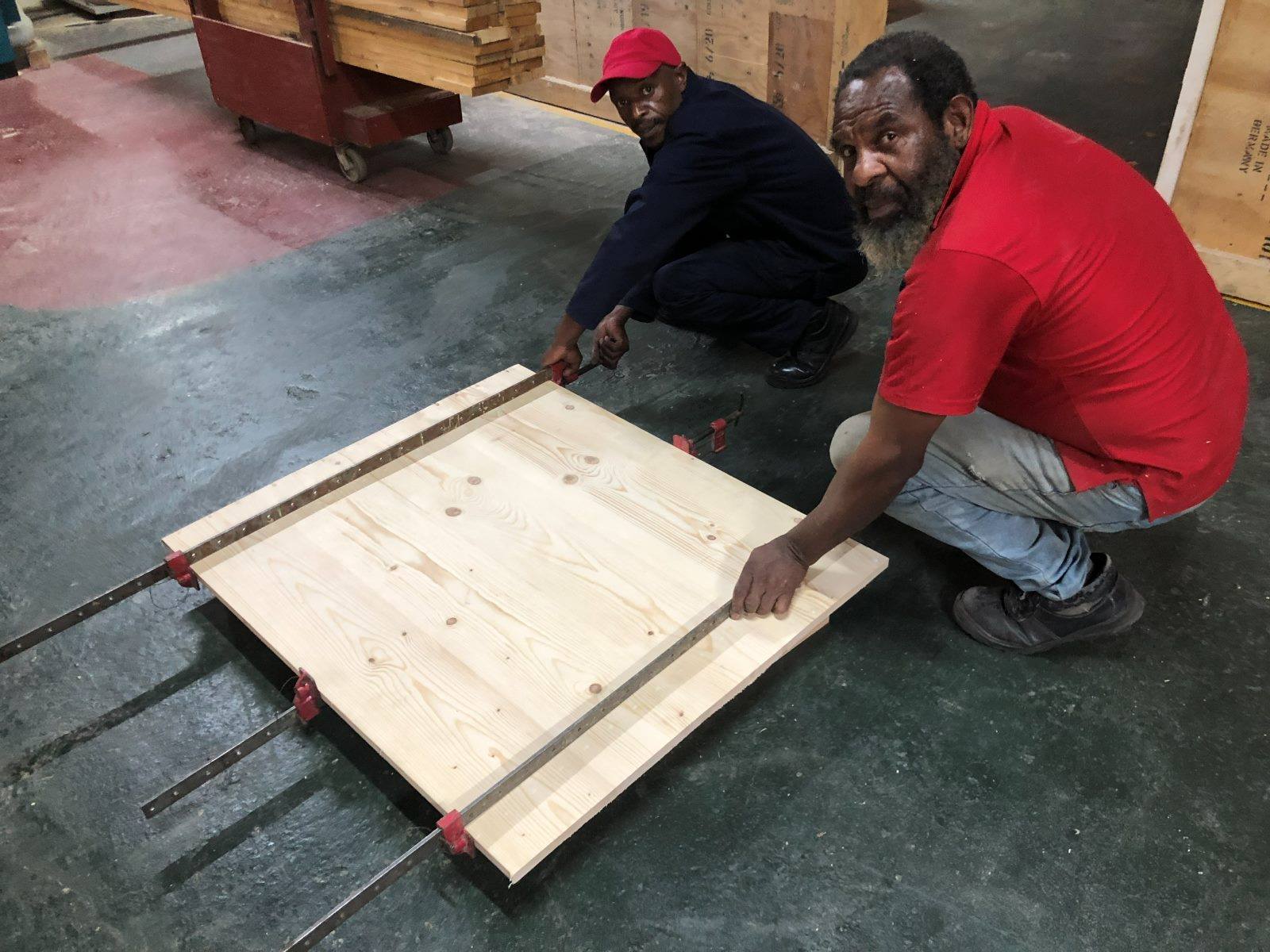 Two of the team clamping a laminated tabletop