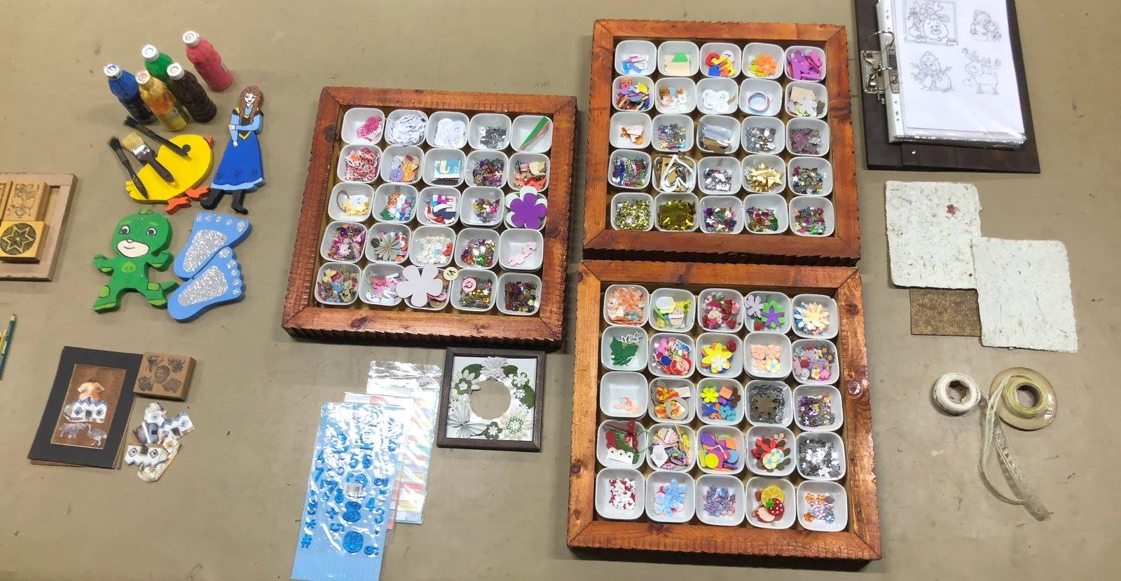 The Craft Bouquet table: trays of bright pieces, stamps, paints and stencils