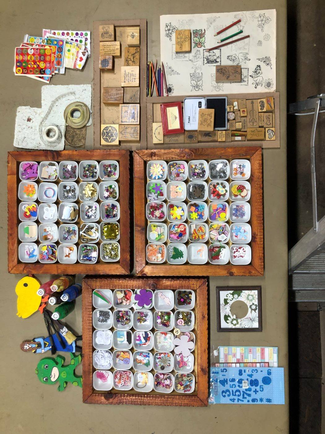 The craft table from above: stamps, stickers and trays of bright pieces