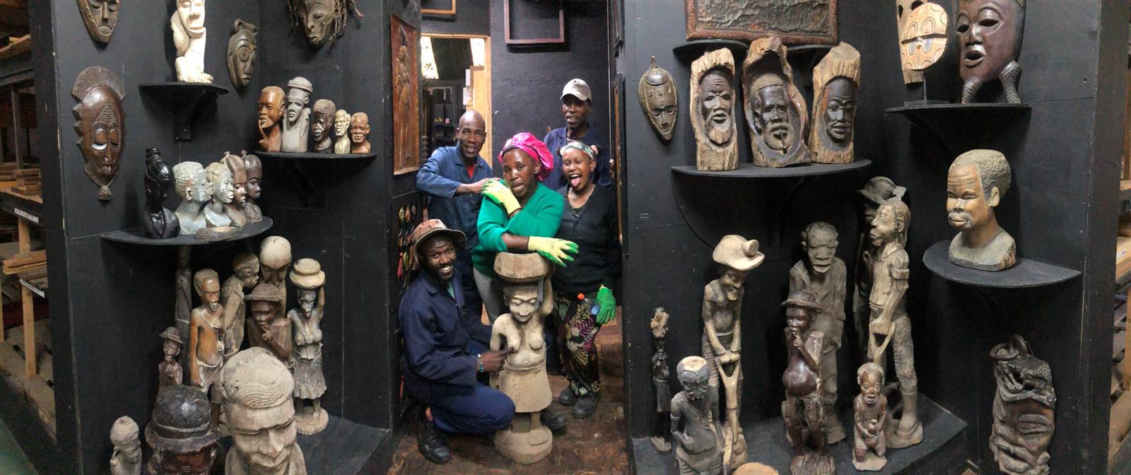 The team among a corner full of wood carvings