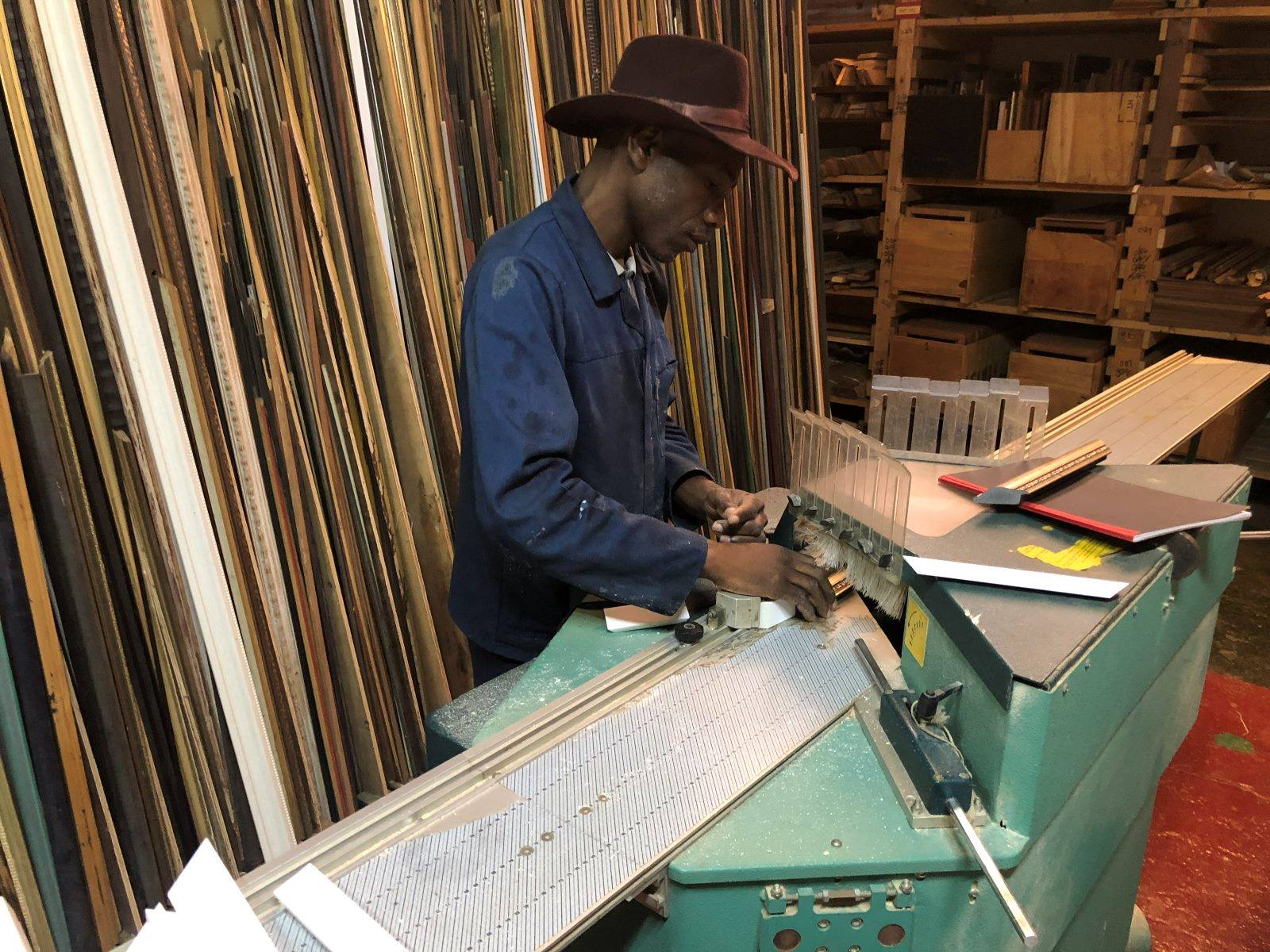 A framer cutting moulding at the mitre saw