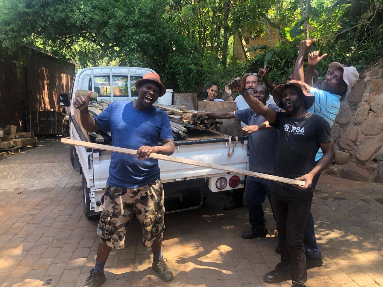 Petros Ngababa NGO and the Heart Eco team, celebrating beside a bakkie loaded with reclaimed timber