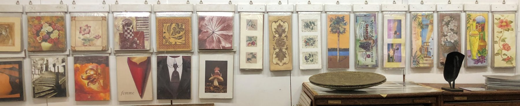 Two long rows of unframed art prints in their sleeves