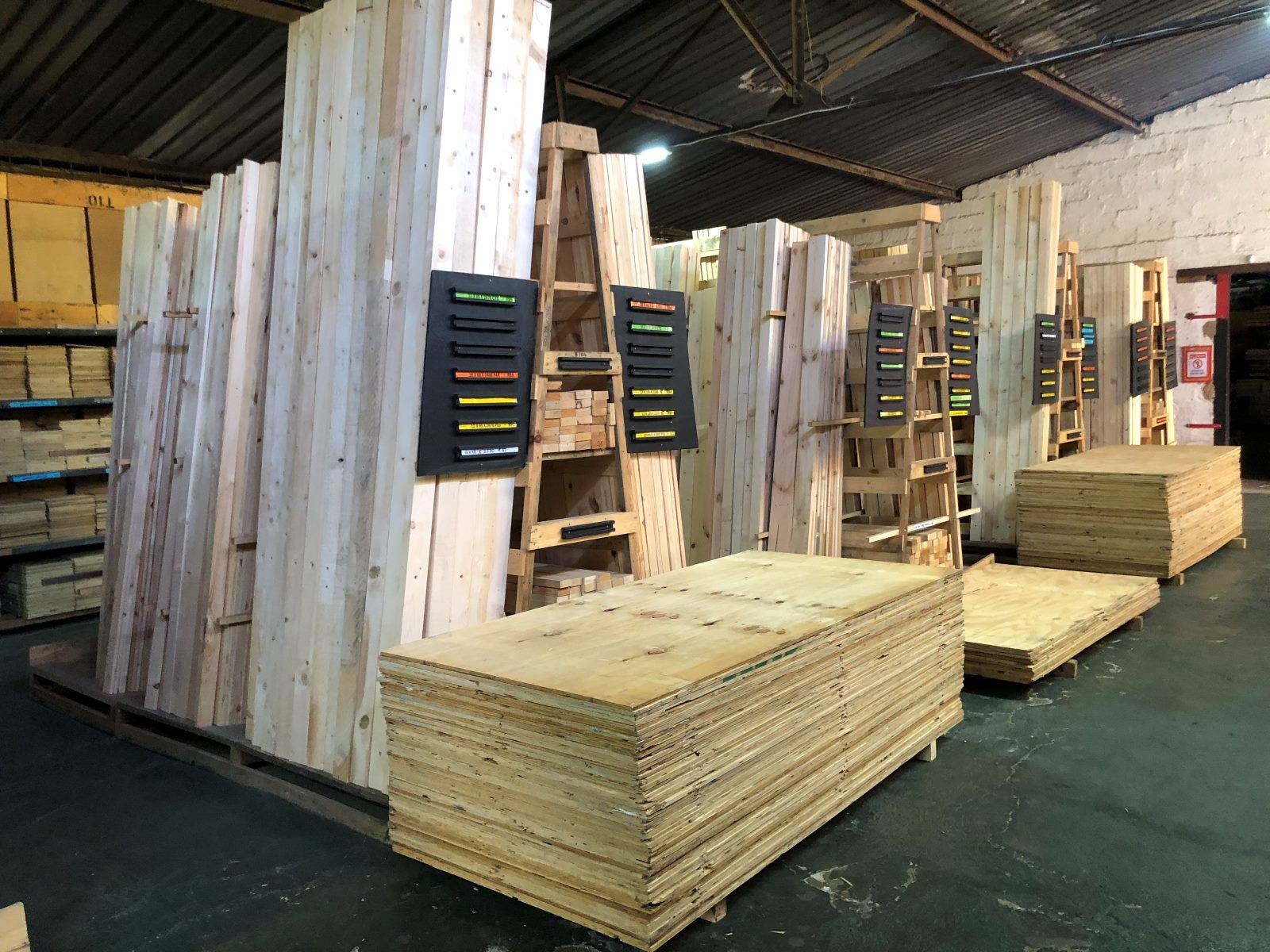 Planed timber in racks and stacked plywood in the timber shop